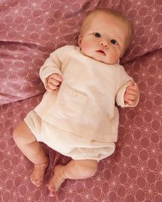 a baby laying on top of a pink blanket