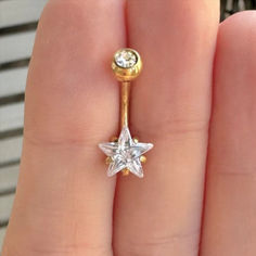 a close up of a person's hand holding a ring with a star on it