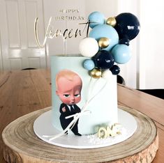 a birthday cake with an image of a baby in a suit and balloons on it