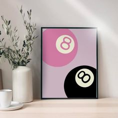 a pink and black poster with the number eight ball on it next to two white vases