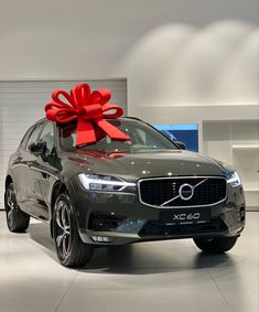 a volvo car with a red bow on the hood