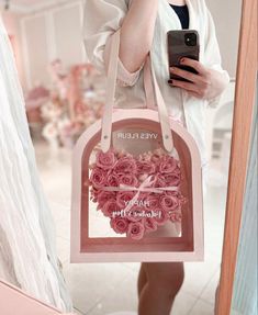 a woman is taking a selfie with her cell phone while holding a pink bag