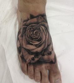 a black and white rose tattoo on the foot