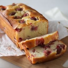 a loaf of strawberry bread sitting on top of a wooden cutting board