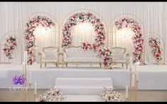 a decorated stage with white couches and flowers