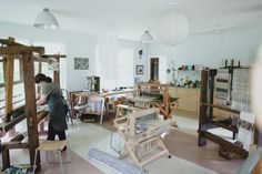 a woman is working in an arts and crafts room with lots of woodworking equipment