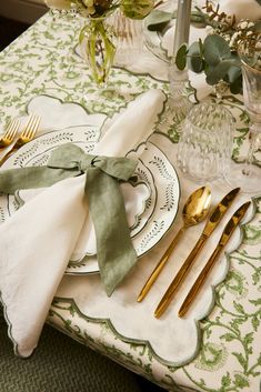 a table set with silverware, napkins and gold - plated utensils