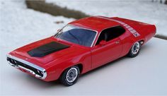 a red toy car sitting on top of snow covered ground