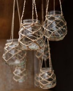 several glass jars are hanging from rope