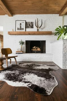 a living room with a fireplace and pictures on the wall