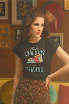 a woman wearing a t - shirt that says, all the cool kids are reading