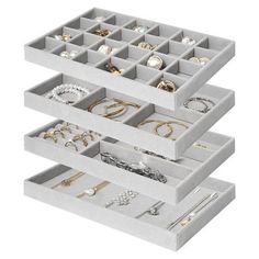 three trays filled with jewelry on top of each other