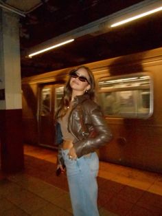 a woman standing in front of a subway train