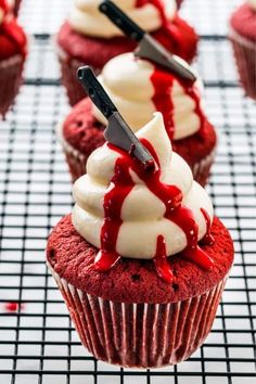 red velvet cupcakes with white frosting and icing drizzled on top