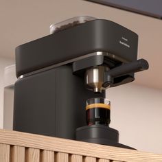 an espresso machine sitting on top of a wooden shelf