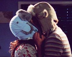 a man and woman hug each other while wearing animal hats on their heads in front of a window