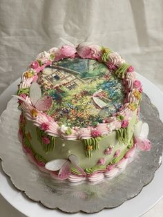 a decorated cake sitting on top of a white platter with flowers and butterflies around it