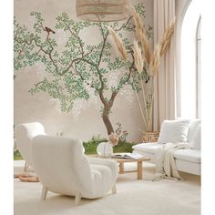 a living room with white furniture and a tree painted on the wall behind it,