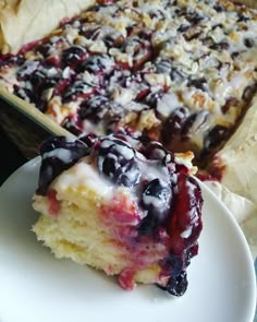 a piece of blueberry cheesecake on a plate next to a casserole dish