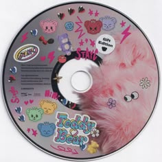 a cd with various stickers on it and a stuffed animal in the disc's center