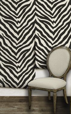 a chair sitting in front of a zebra print wall