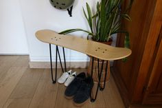 a skateboard and shoes are on the floor in front of a wall mounted clock