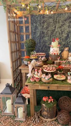 a table topped with lots of cakes and cupcakes on top of green grass