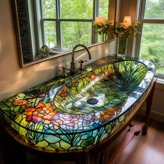 a stained glass sink in front of a large window with flowers on the bottom and sides