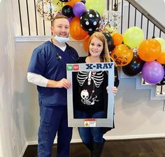 a man and woman standing next to each other holding up a framed x - ray t - shirt