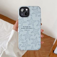 a person holding up a phone case with starfishs on it and the words he leads me through all matters