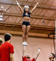 a cheerleader is doing tricks on the court while others watch from the sidelines