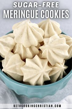 a blue bowl filled with sugar - free meringue cookies on top of a white cloth