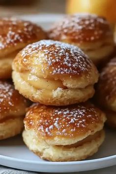 a white plate topped with powdered sugar covered donuts