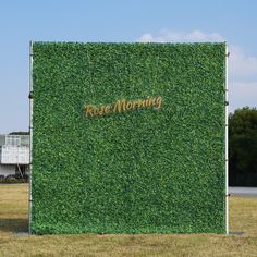 a tall green wall covered in grass with the words rise morning on it's side