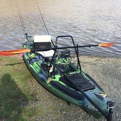 a green and black kayak sitting on the shore