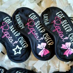 four personalized black and pink slippers on top of white tissue paper with bows