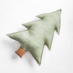 a green pillow with a wooden tree on it's back and the shape of a christmas tree