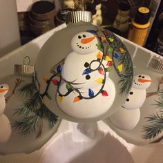 a snowman ornament hanging from a christmas tree