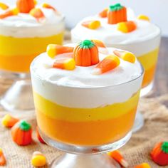 three desserts with candy corn on top and frosting in the middle, sitting on a table