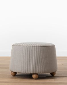 a round ottoman sitting on top of a wooden floor