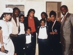 a group of people standing next to each other in front of a wall with a door