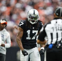 a football player with dreadlocks standing on the field