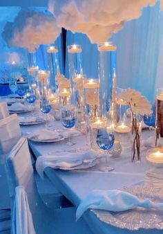 a long table is set with white flowers, candles and glass vases for centerpieces