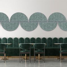 a row of green chairs sitting next to each other in front of a white wall