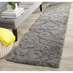 a large gray rug on top of a wooden floor next to a couch and chair