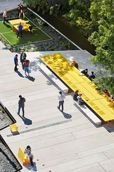 an aerial view of people playing tennis on a court with benches and tables in the foreground