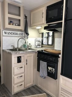 a kitchen with white cabinets and black appliances