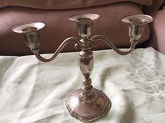 two silver candlesticks sitting on top of a bed