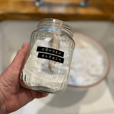 a hand holding a mason jar filled with water