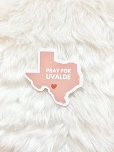 a sticker with the word pray for uvalde on it sitting on a furry surface